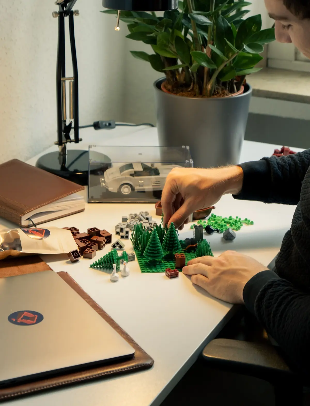Ein Tisch, auf dem eine Person mit vielen Penny Bricks Klemmbausteinen kreativ etwas zusammenbaut.
